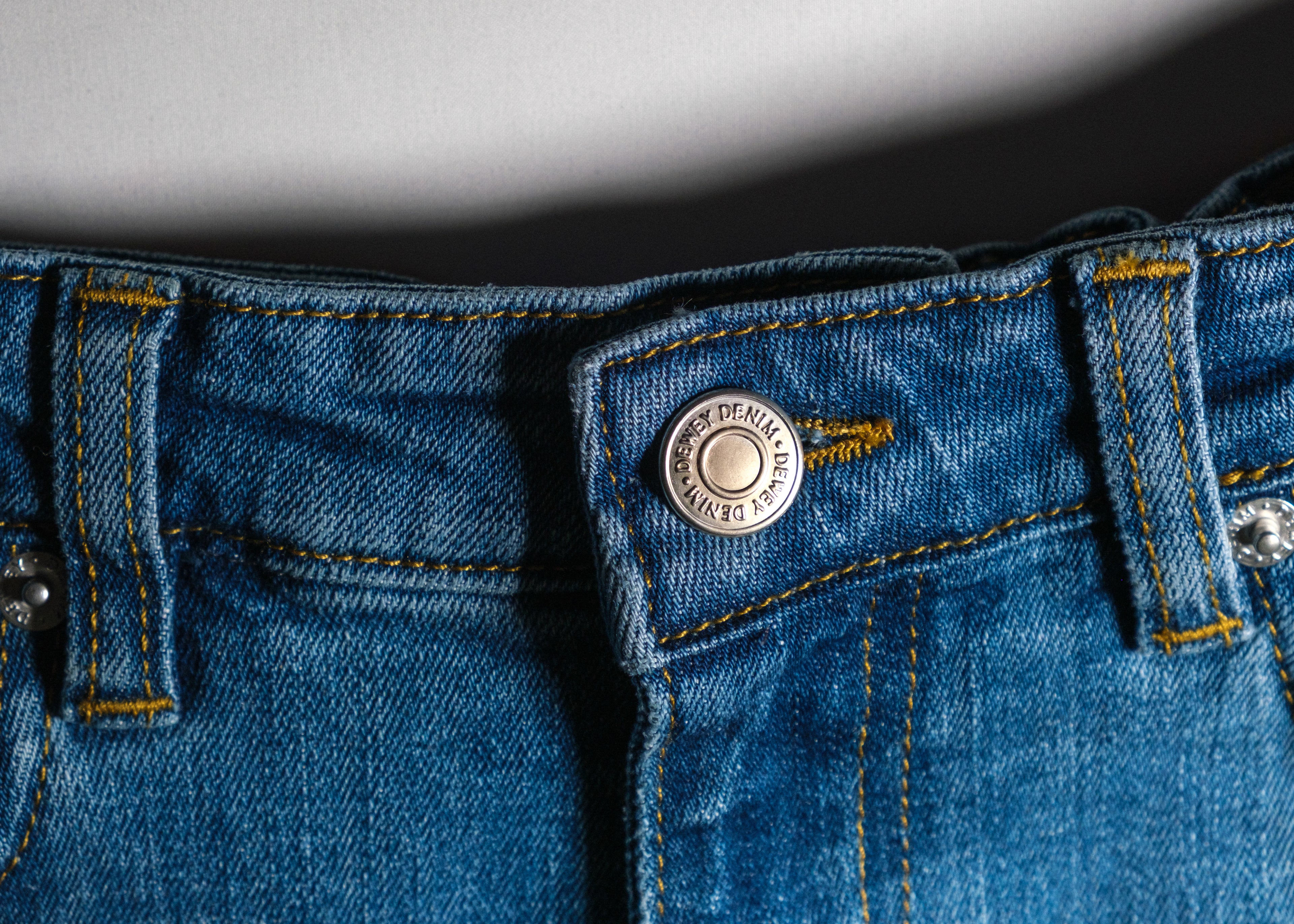 a close up of a button on a blue jeans