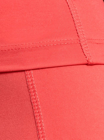 Close-up of coral red fabric with visible seam stitching on DEWEY’s IRIS High Waist Leggings (Extra Petite), highlighting the geometric pattern and quality construction of these activewear essentials.
