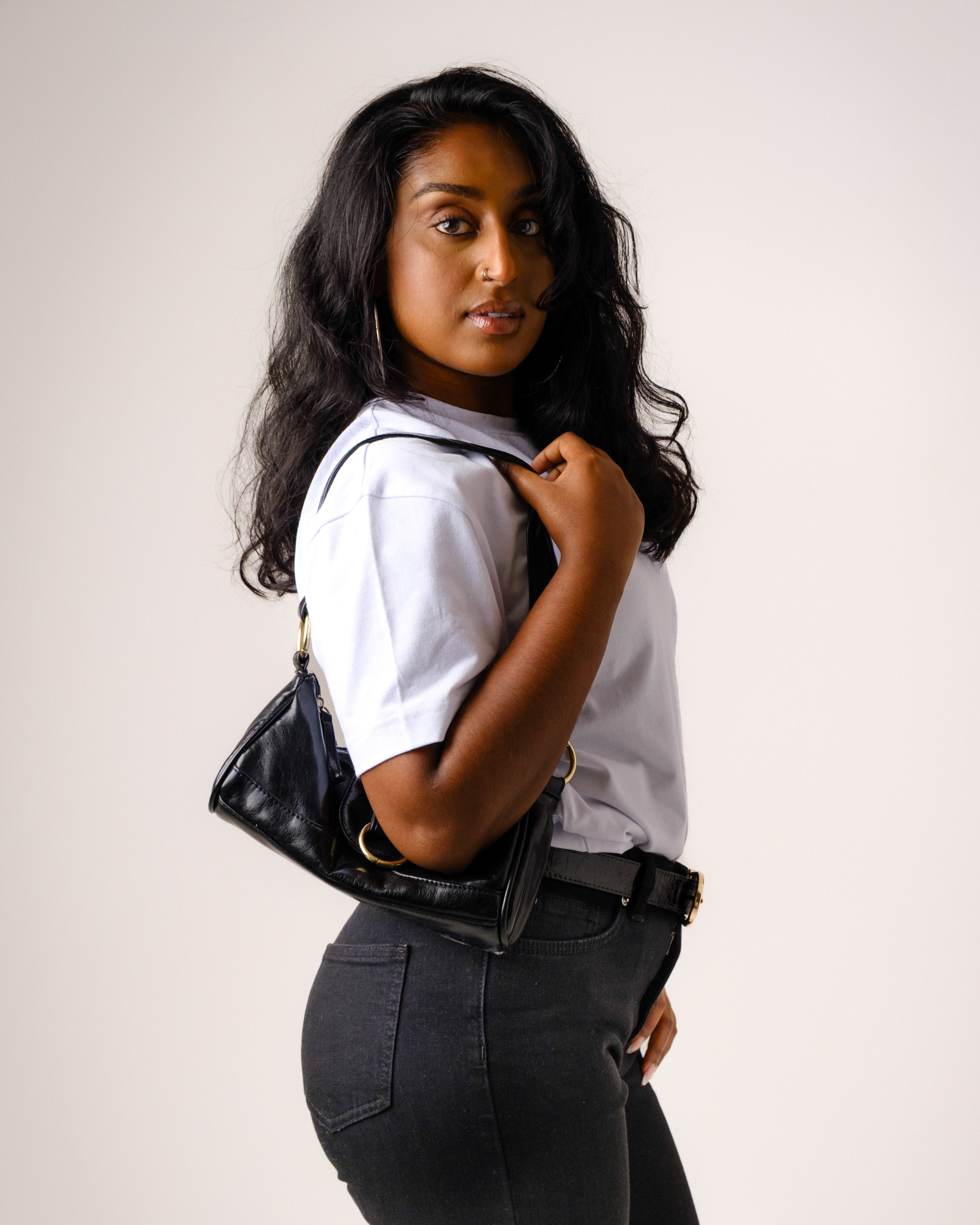 a woman with long black hair holding a purse