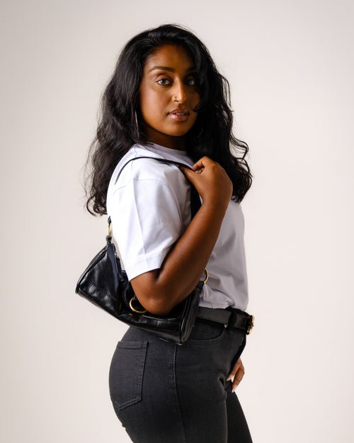 a woman with long black hair holding a purse