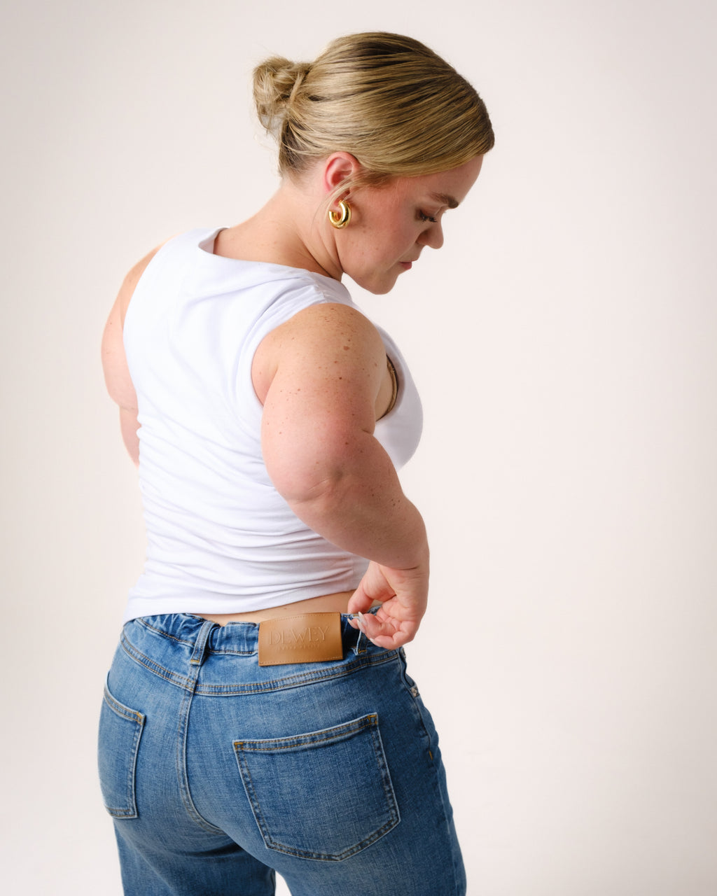 a woman pulling her pants out of her jeans