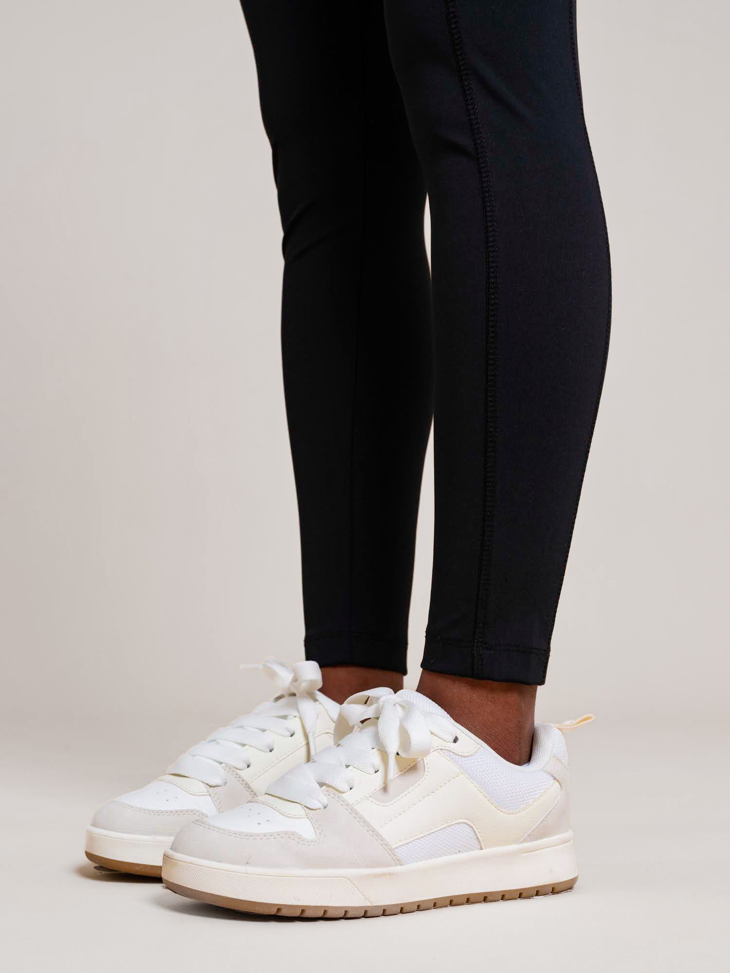 a person's legs and white sneakers