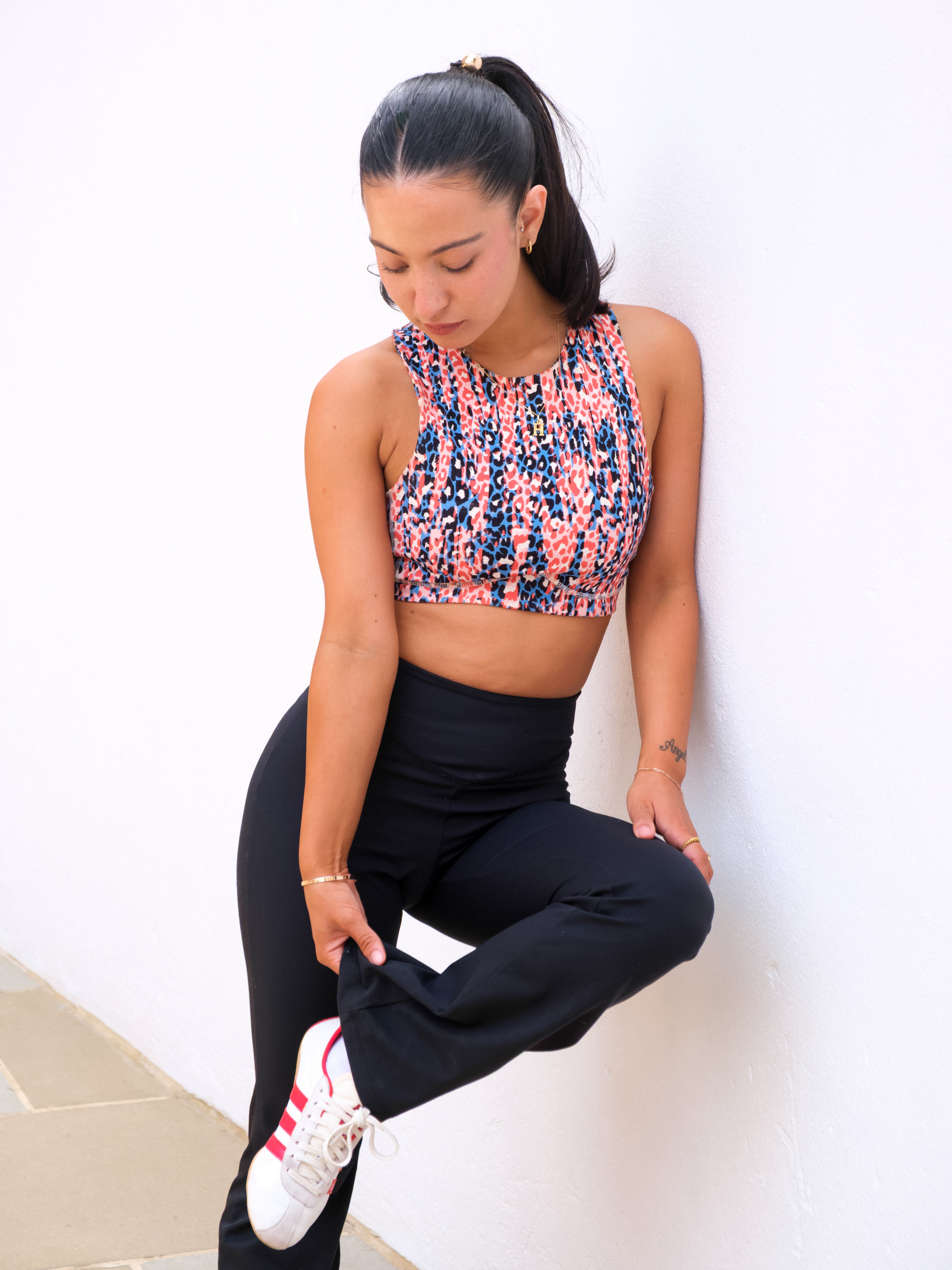 a woman wearing a crop top and black pants