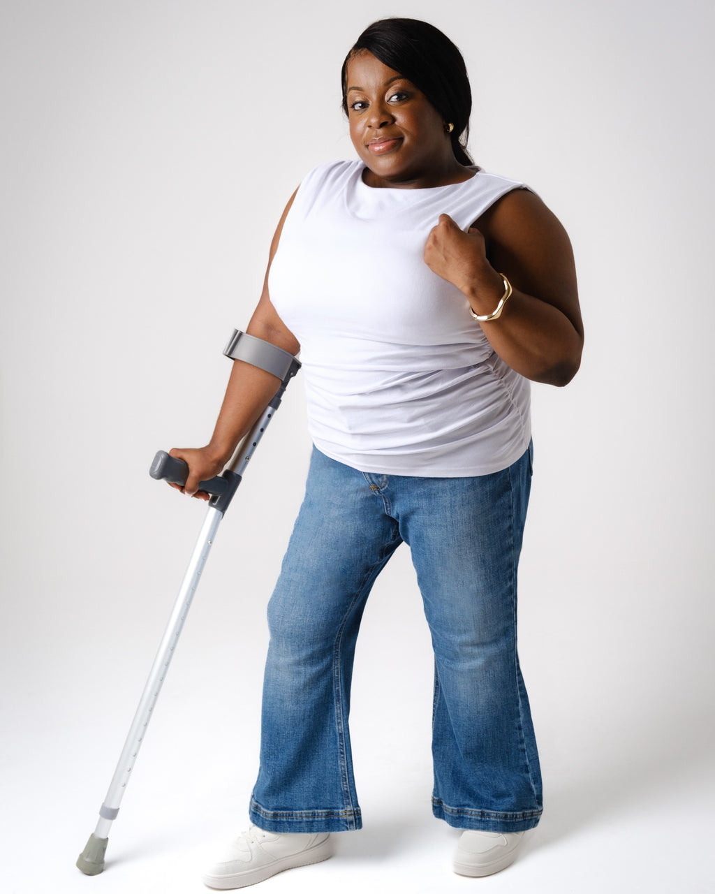 a woman with crutches and arm raised